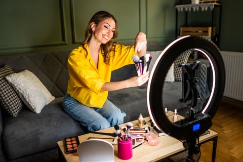 Influencer creating social media content with ring light and smartphone